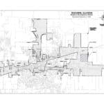 Black and white map showing the boundaries of the Business Development District in Macomb, Illinois, with labeled streets, shaded areas, and a north arrow for orientation. Map title and establishment date appear in the top right corner.